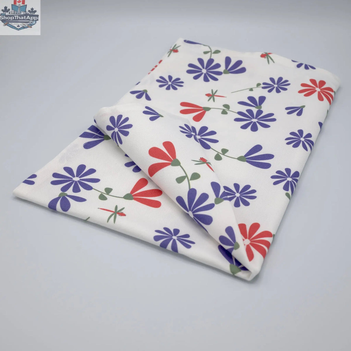 Printed purple and pink Shy Dragonfly tea towel from Hem and Tassel, folded to showcase the colorful dragonfly design.