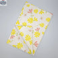 Printed Shy Dragonfly tea towel by Hem and Tassel, unfolded with yellow and blush floral design, showcasing vibrant kitchen decor.