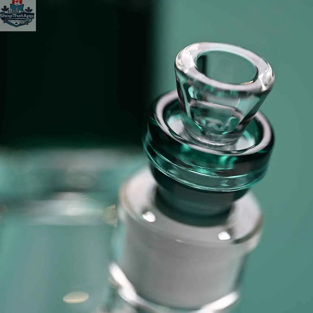 Close-up of Castle Glassworks teal-colored 16-inch borosilicate glass beaker bong with a detailed bowl on a teal background.