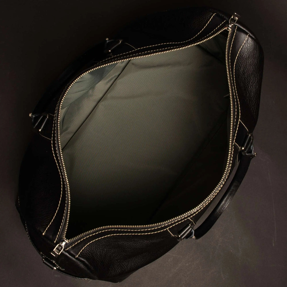 Black full-grain leather duffle bag by NAB Leather, showcasing sturdy handles and sleek design, made in Canada.