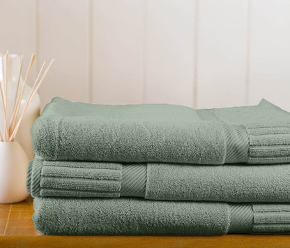 Stack of Zenith Turkish bath sheets from Skylark+Owl Canada in sage green, showcasing soft, plush towels for luxurious comfort.