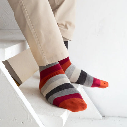 Orange and grey striped socks by Velvet and White, showing a close-up of the stylish, comfortable sock design.