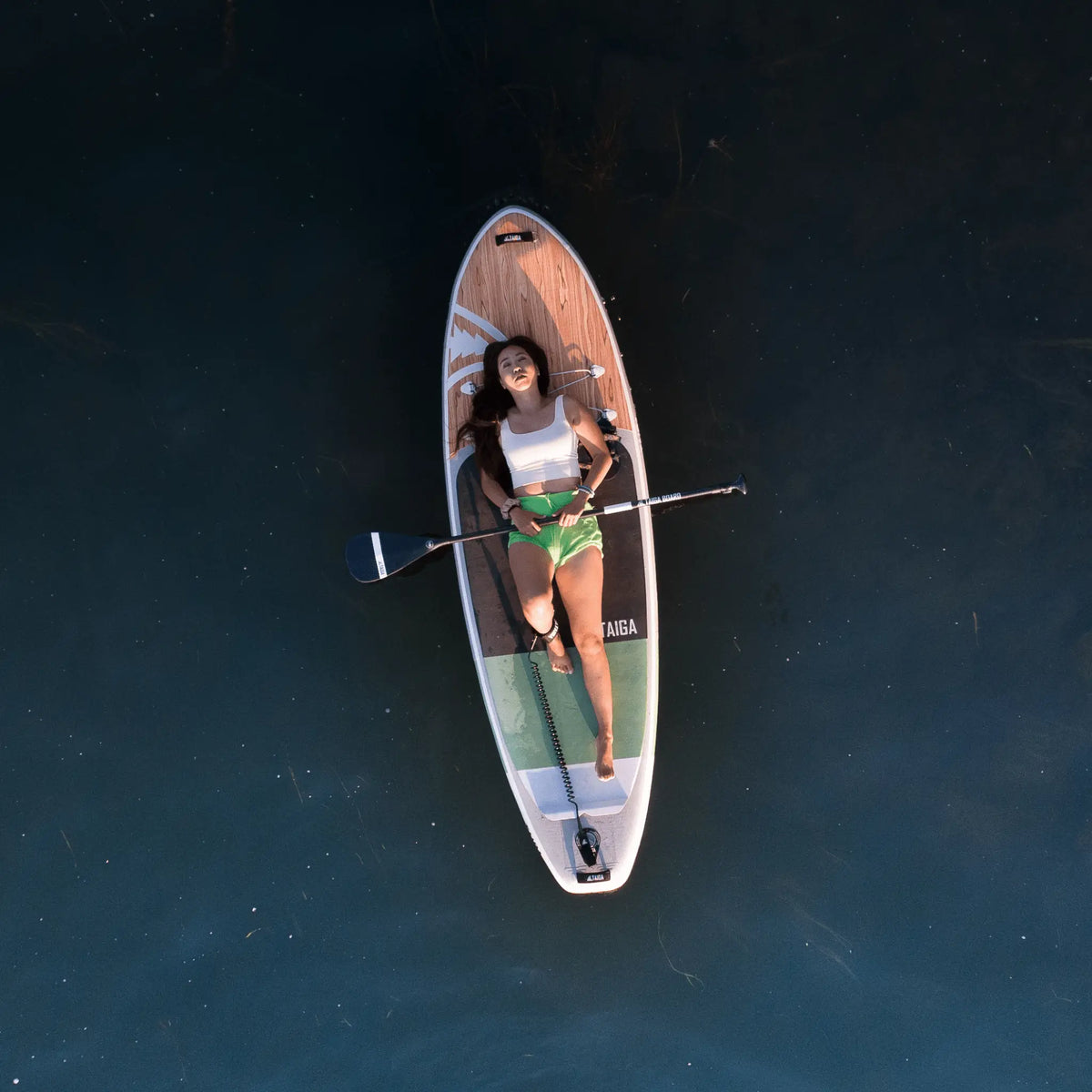 Inflatable Taiga Board AKOYA 9'5'' SUP paddle board on water, showing its sleek design and portable construction.
