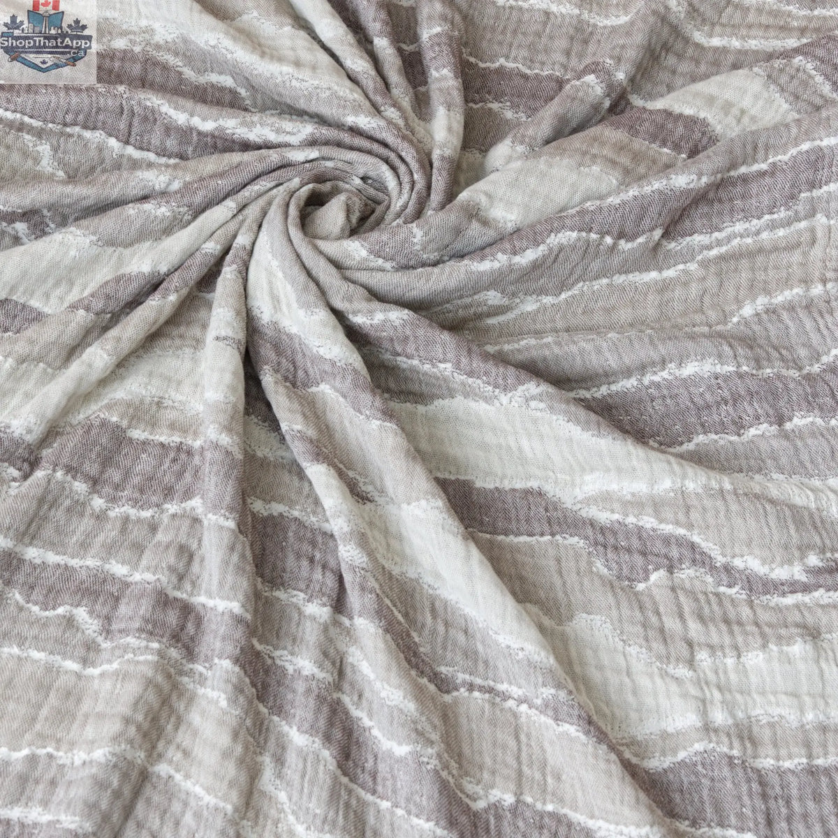 Beige cotton throw blanket with waves pattern from Hem And Tassel, showcasing soft seersucker fabric and tassel details.