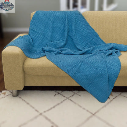 Blue double-waffle cotton throw blanket from Hem And Tassel draped over a sofa for cozy home decor.