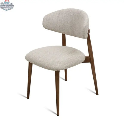 Beige fabric Cammy dining chair with walnut angled legs from Hygge Design House, shown from an angled side view.