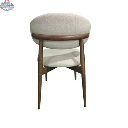 Rear view of Hygge Design House Cammy dining chair with beige fabric upholstery and walnut wood legs.