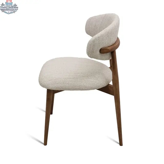 Side view of Hygge Design House Cammy Dining Chair with beige fabric upholstery and walnut wood legs.