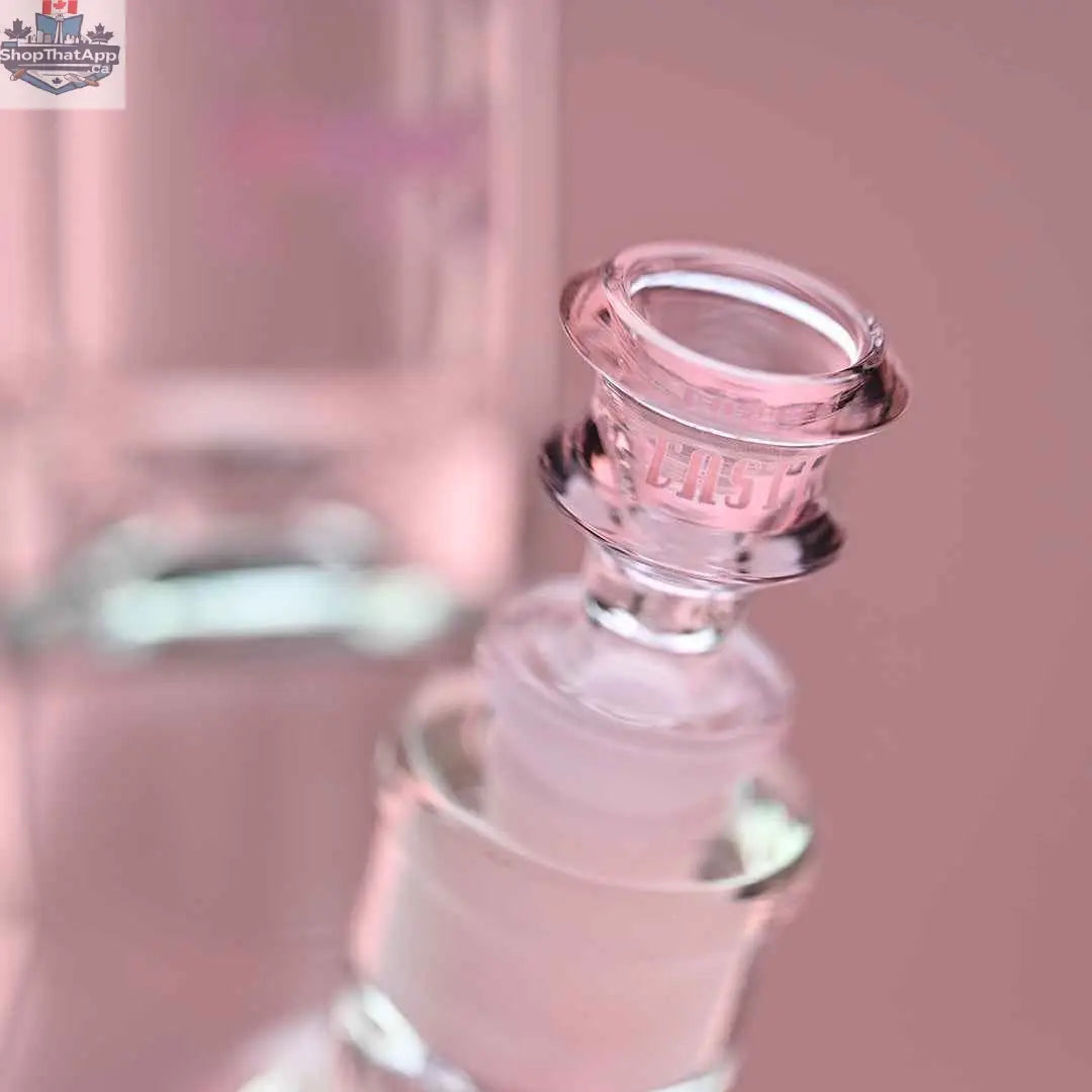 Castle Glassworks 14-inch beaker bong with pink logo, 9mm thickness, and 9-hole downstem, shown with pink background and close-up bowl.