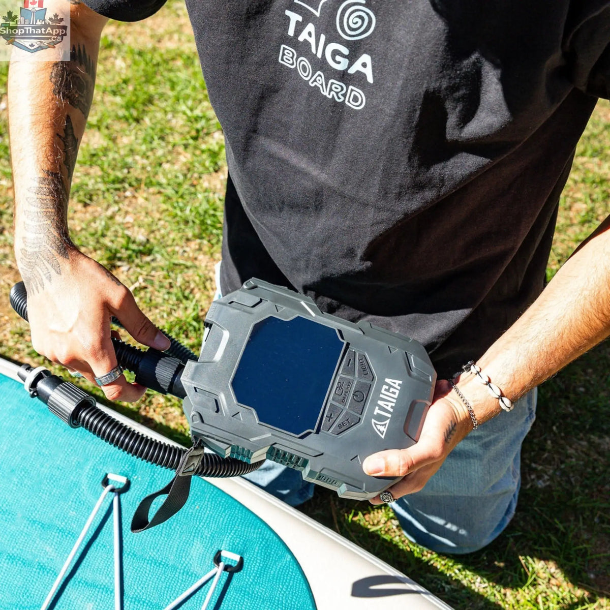 Taiga Board premium electric pump for paddle boards, battery-operated inflator with comfort bundle setup, inflating an inflatable SUP.