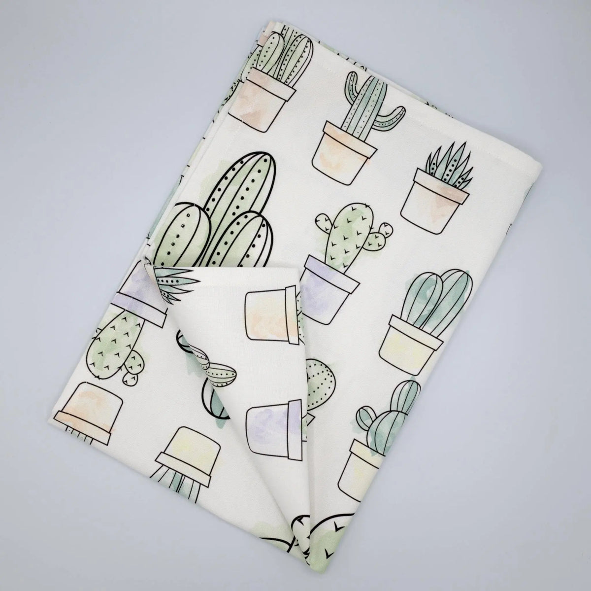 Hem And Tassel Desert Haze watercolor cacti printed kitchen towel folded, featuring vibrant desert plant artwork.