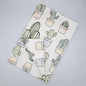Hem And Tassel Desert Haze watercolor cacti printed kitchen towel folded, featuring vibrant desert plant artwork.