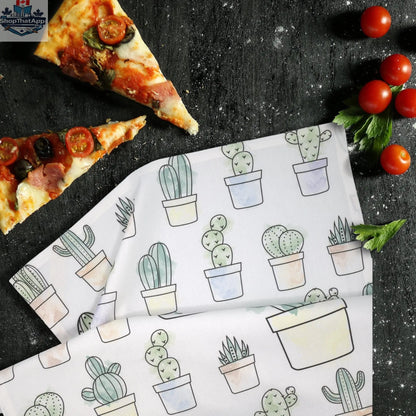 Printed kitchen towel featuring Desert Haze cacti watercolor artwork by Hem And Tassel, displayed on a kitchen counter.