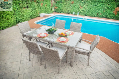 Enclover Tulip outdoor dining set with seven pieces, including table and chairs with Sunbrella® cushions, on a patio.
