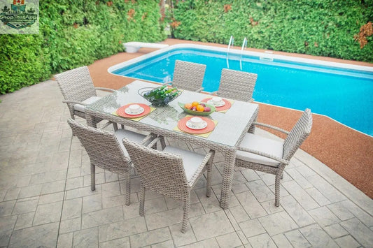 Enclover Tulip outdoor dining set with seven pieces, including table and chairs with Sunbrella® cushions, on a patio.