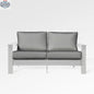 Enclover Hickory loveseat with white Sunbrella cushions, outdoor jasmine sofa featuring a sturdy hickory frame and comfortable seating.