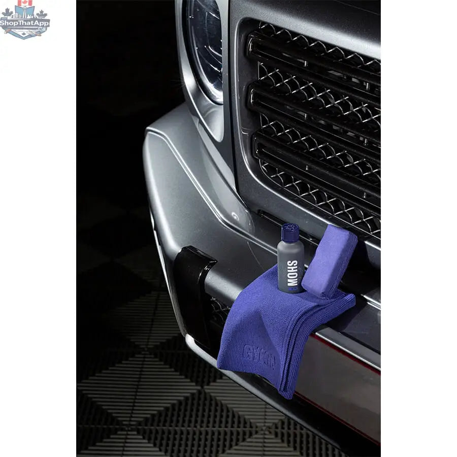 GYEON Q² Mohs EVO lightbox showing ceramic coating application on a car surface with reflective finish.