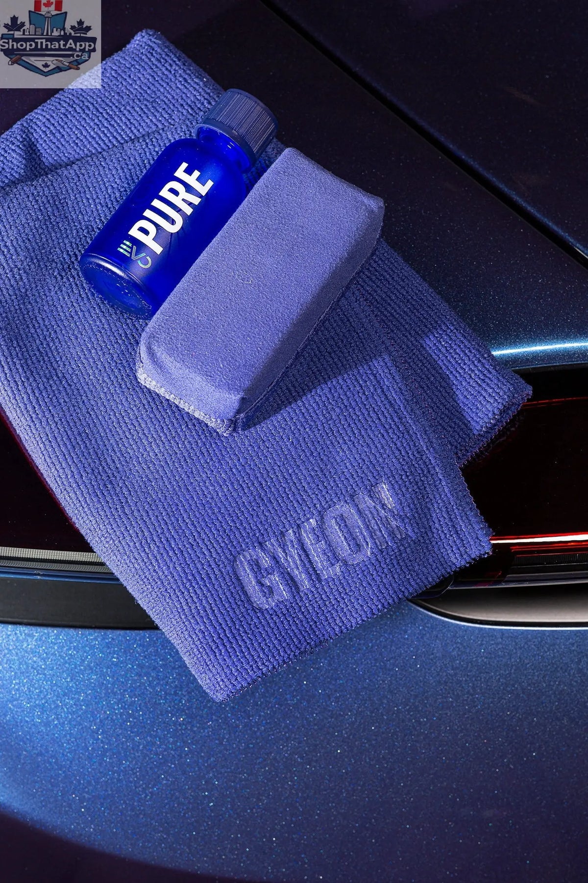 GYEON Q² Pure EVO Lightbox ceramic coating displayed with application tools and sample car surface for automotive protection testing.