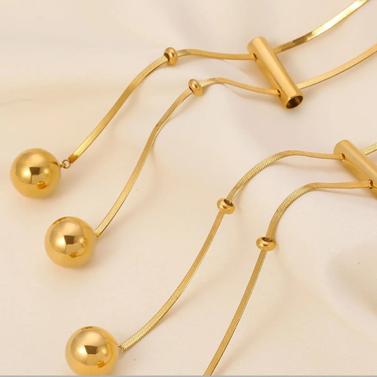 18K gold-plated titanium necklace featuring a hollow bead design, showcasing a sleek and modern jewelry piece.