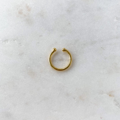 Gold ear cuff from HoraceJewelry featuring a simple, elegant design in a basic style, shown on a model's ear.