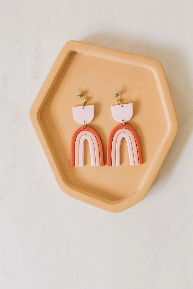 Colorful handmade rainbow earrings hanging from ears, vibrant accessory with bright, multicolored design, perfect for casual or festive outfits.