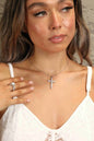 Sterling silver cross necklace with sparkling moissanite gemstone, elegant jewelry piece with detailed design and polished finish.