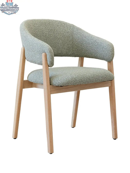 Mint green upholstered Fiol dining chair with natural wood frame by Hygge Design House, showing the stylish seat and wooden legs.