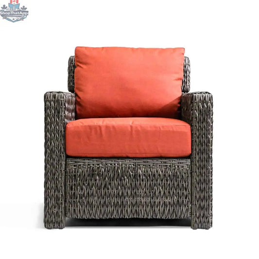 Brown Krikacy Laguna Point wicker club chair with orange cushions, designed for stylish outdoor patio relaxation.