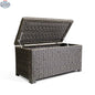 Open Laguna Point wicker outdoor storage chest coffee table by Krikacy with park meadow wicker chair in a backyard setting.
