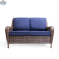 Krikacy Cambridge brown wicker outdoor loveseat with indigo cushions, showcasing a cozy seating area with woven wicker design.