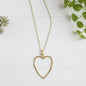 Gold plated chain necklace featuring an open heart pendant, styled as a fashionable jewelry accessory.