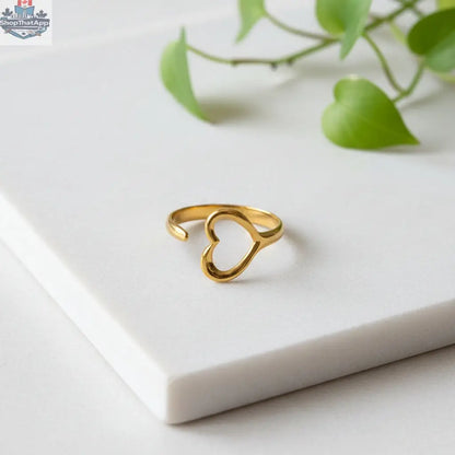 Gold plated single open heart ring by Suzie Blue Canada, styled on a finger in a lifestyle setting.