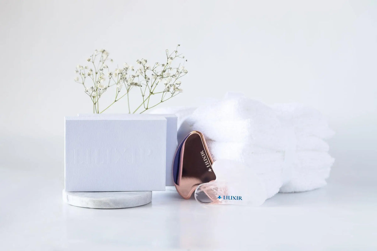 LILIXIR gift set with golden and white gua sha tools for morning skincare routine, featuring sleek, polished stone massage tools.