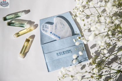 White crystal Gua Sha tool by LILIXIR for acupressure and skincare, shown with massage stones for facial and body massage.