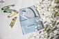White crystal Gua Sha tool by LILIXIR for acupressure and skincare, shown with massage stones for facial and body massage.