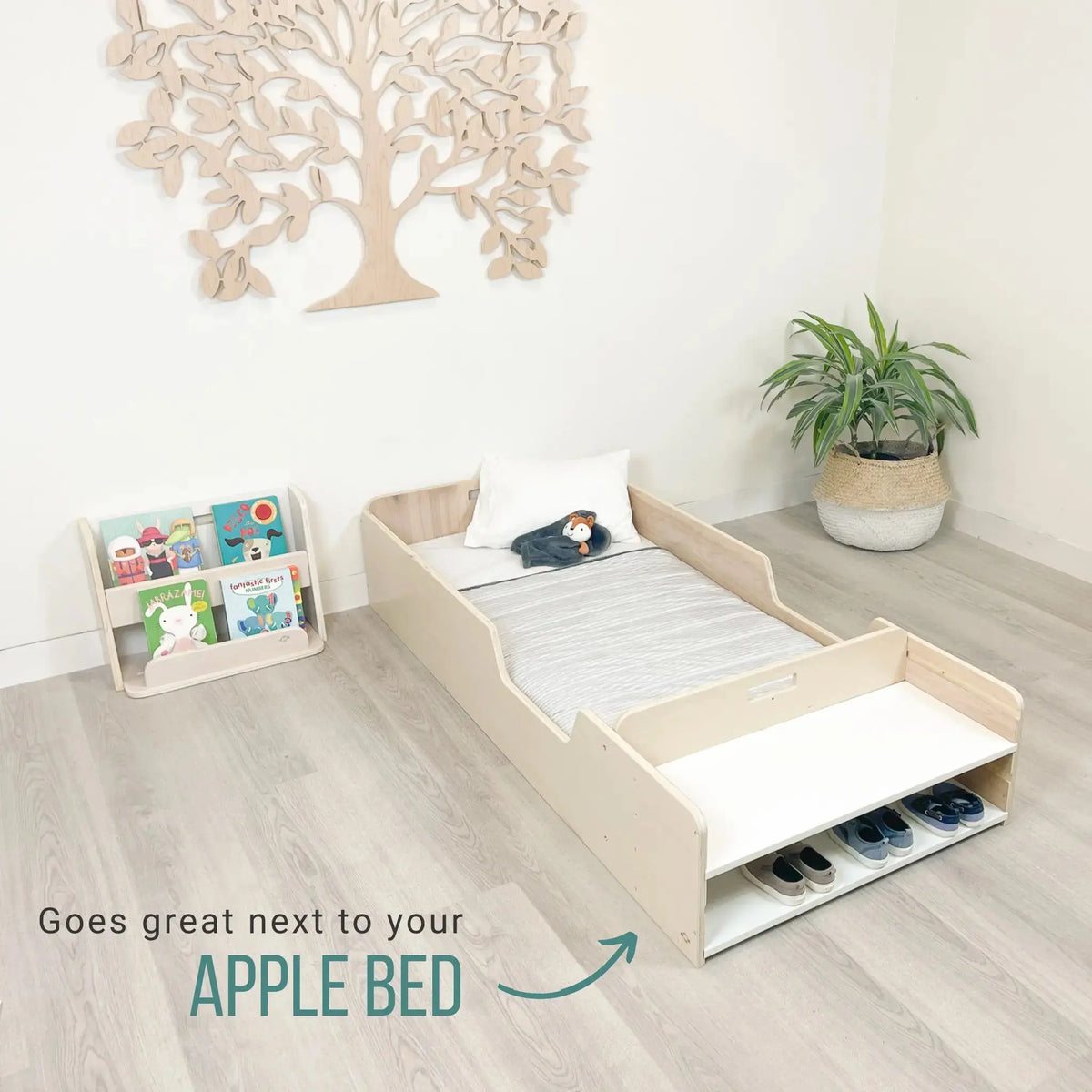 Sapiens Child GUAVA Montessori bookshelf for kids, front view with shelves next to a toddler's floor bed, wooden furniture for learning.