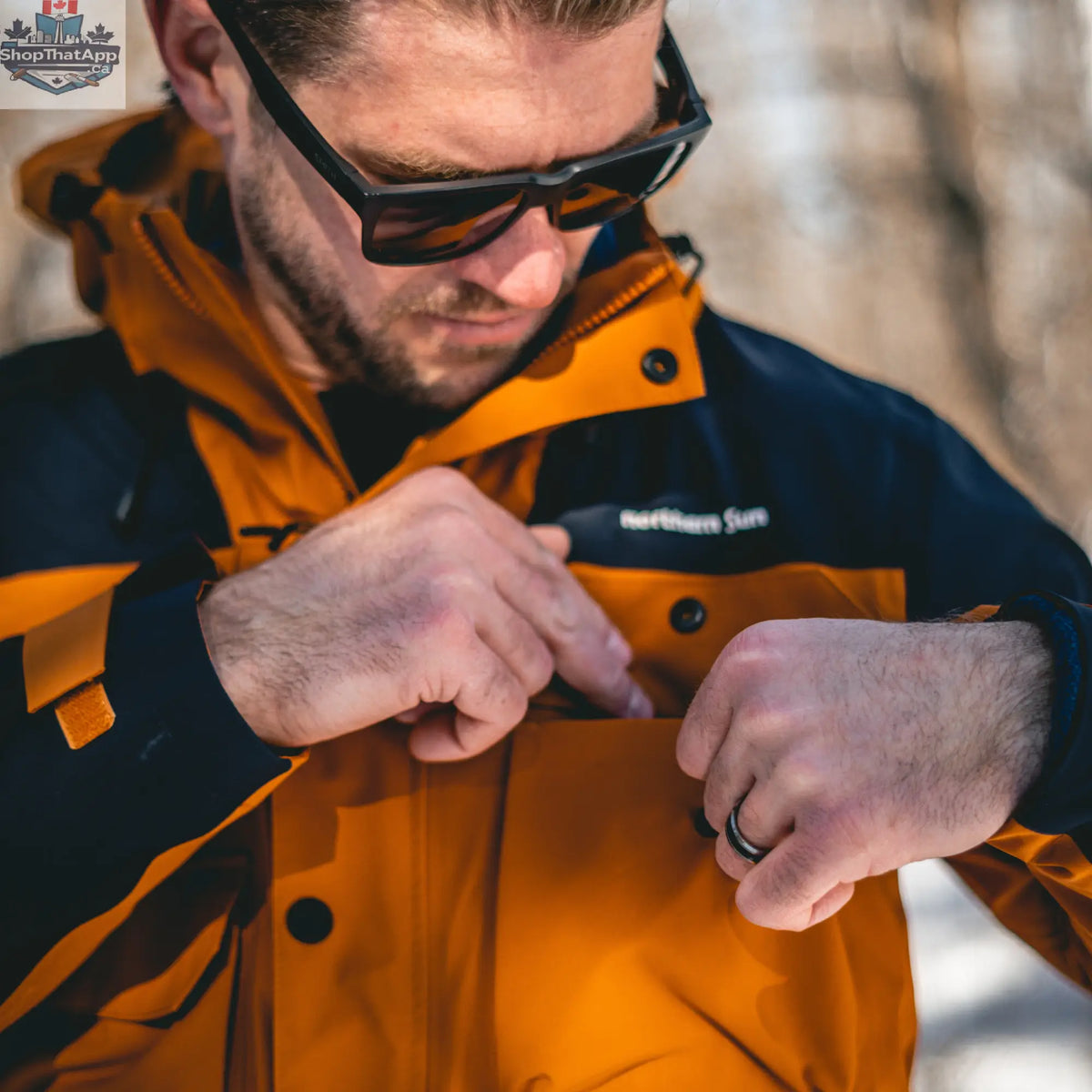 Northern Sun men's 3-in-1 waterproof winter parka in orange and blue with zip pockets, suitable for cold weather in Canada.