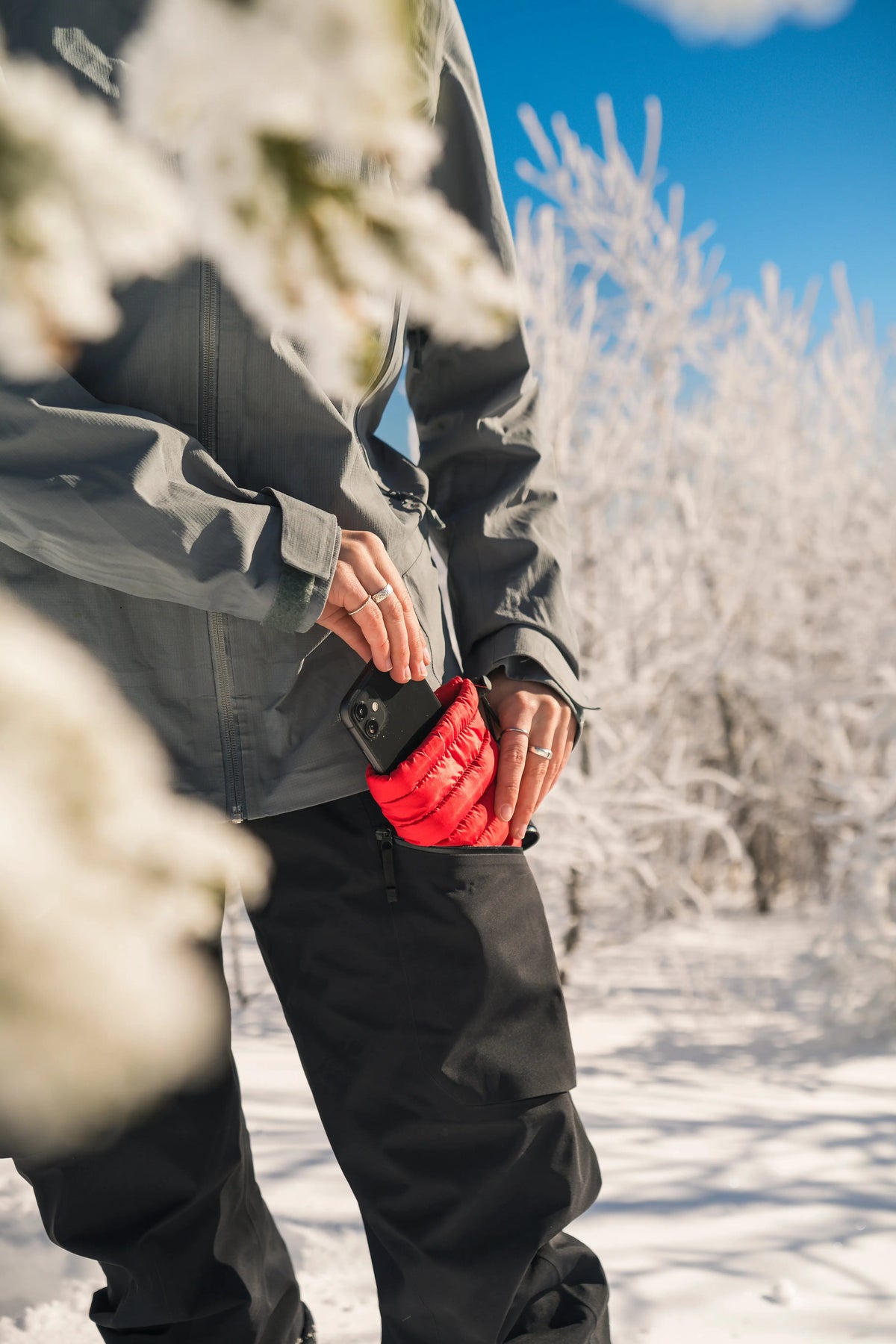 Hot Poc Eco Reusable Heat Pack designed for outdoor phone protection, shown protecting a smartphone outdoors in the image.