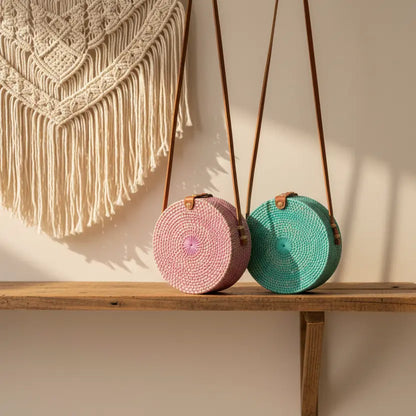 Pink round rattan purse with a chic design, featuring a woven texture and top handle, perfect for stylish occasions.