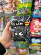 Gelatin-free salty licorice skull candies from Bubs Godis by Snack Bar Co, with black and white skull shapes on a white background.