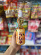 Orange HATA Ramune soda bottle from Snack Bar Co, Japanese carbonated drink with a distinctive glass bottle and colorful label.