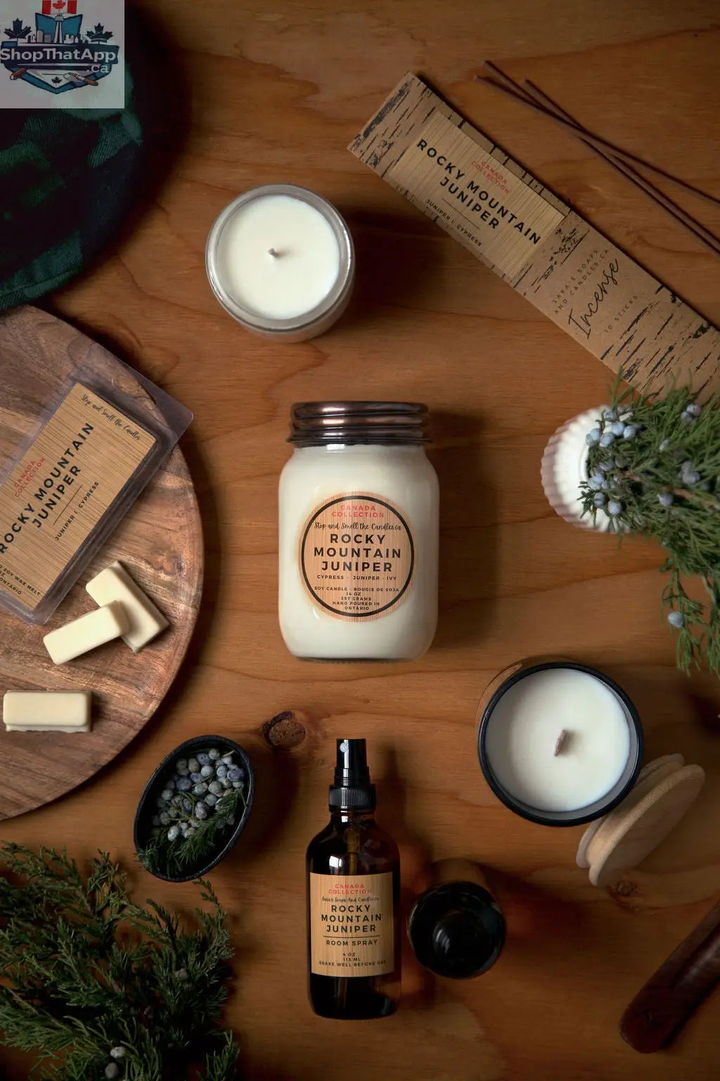 Stopandsmellthecandles Rocky Mountain Juniper soy candle in 8oz jar with a wooden wick, surrounded by juniper branches and natural elements.