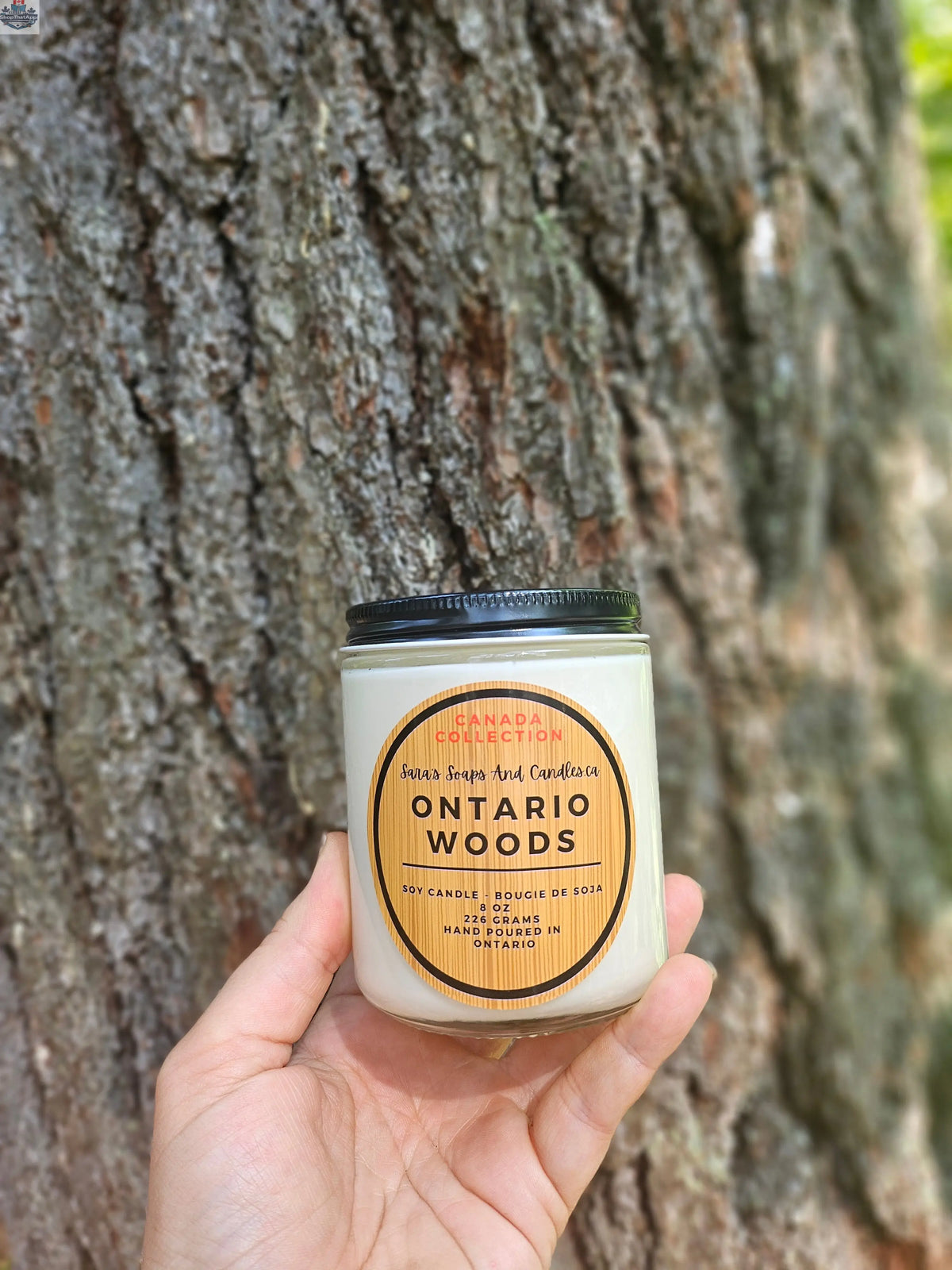 Ontario Woods soy candle by Stopandsmellthecandles, 8 oz jar with a lit wick and wooden lid, emitting a warm, cozy glow.