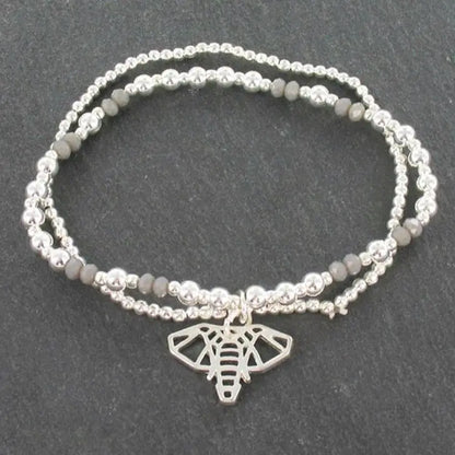 Silver bracelet featuring a double strand elephant pendant from Suzie Blue Canada, showcasing detailed elephant charms on the bracelet.