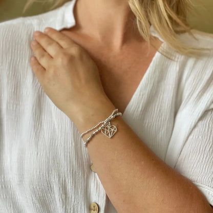 Silver plate double strand heart pendant bracelet by Suzie Blue Canada, featuring layered heart charms on a delicate chain.