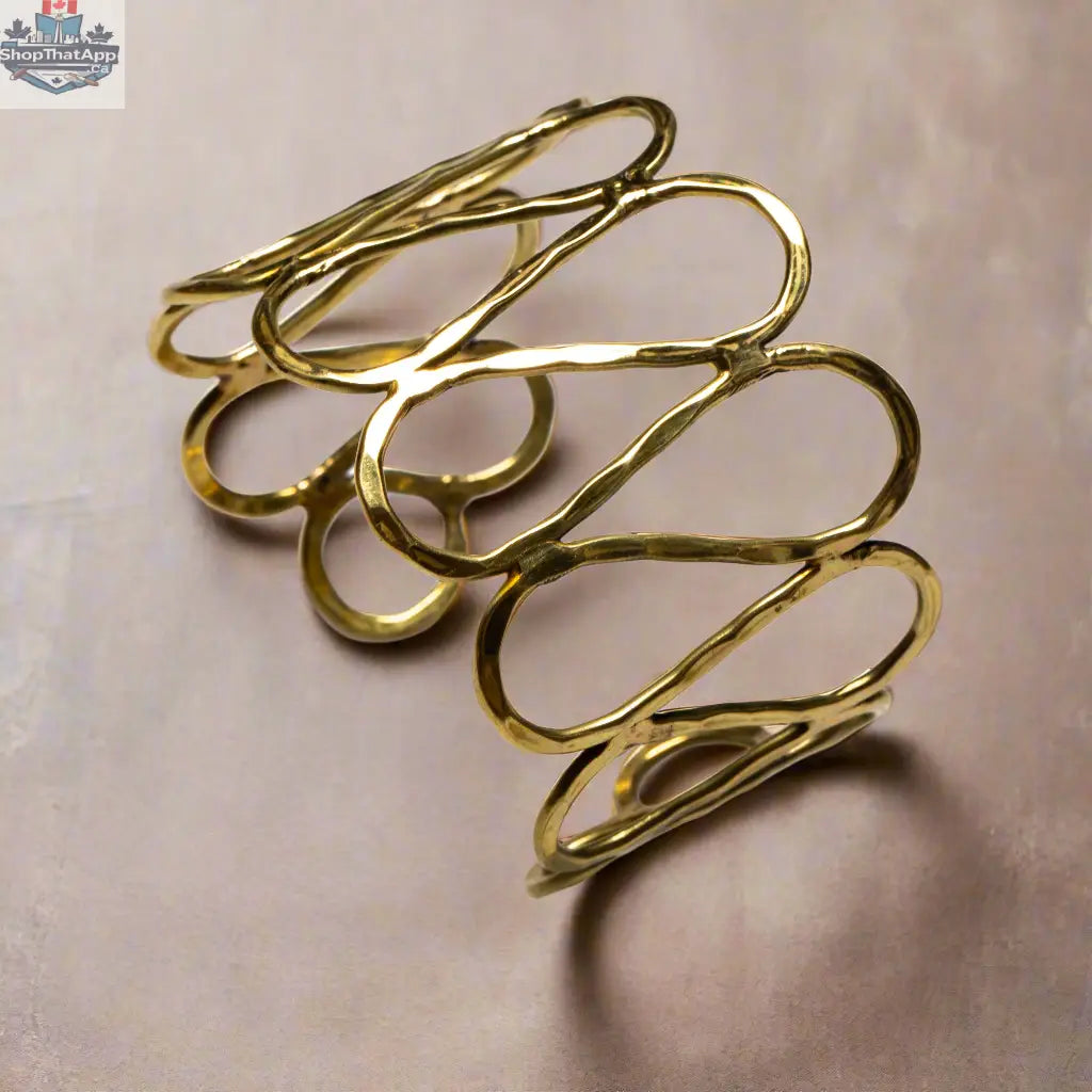 Gold open loop metal bracelet by Suzie Blue Canada featuring a sleek, modern design perfect as a stylish statement accessory.