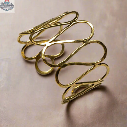 Gold open loop metal bracelet by Suzie Blue Canada featuring a sleek, modern design perfect as a stylish statement accessory.