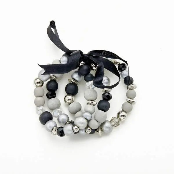 Set of three wooden bracelets by Suzie Blue Canada featuring natural wood beads and stylish design for versatile occasions.