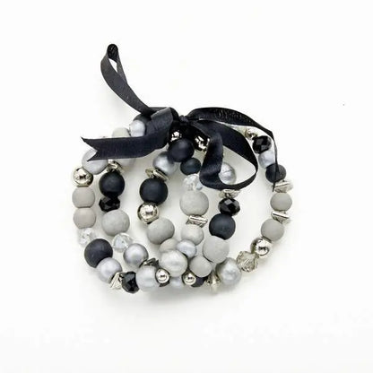 Set of three wooden bracelets by Suzie Blue Canada featuring natural wood beads and stylish design for versatile occasions.