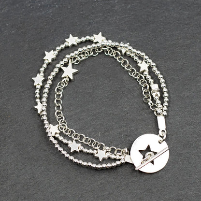 Silver star charm bracelet by Suzie Blue Canada featuring multi-strand design and T-bar clasp on a white background.